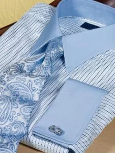 Stack of custom light blue dress shirts featuring intricate paisley patterns on the cuffs and collar, demonstrating high-quality fabric options and bespoke detailing at From Collars to Cuffs in South Florida