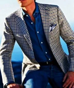 Man wearing a custom grey houndstooth sport jacket paired with a blue dress shirt and jeans, showcasing bespoke smart casual fashion at From Collars to Cuffs in South Florida