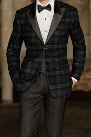 Model wearing a custom dark plaid tuxedo jacket with black satin lapels and bow tie, showcasing distinctive bespoke formal fashion at From Collars to Cuffs in South Florida.