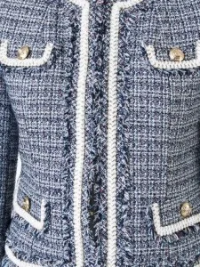 Close-up detail of a custom blue and grey tweed jacket with white contrast piping and gold buttons, highlighting Chanel-inspired craftsmanship at From Collars to Cuffs in Weston, Florida