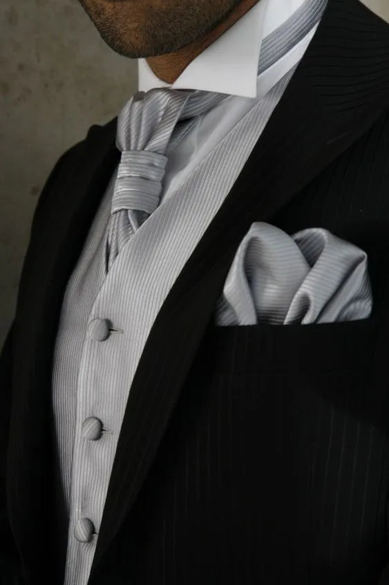 Close-up of a custom black tuxedo featuring a silver vest, gray tie, and matching pocket square, highlighting sophisticated bespoke formal layering at From Collars to Cuffs in Weston, Florida.