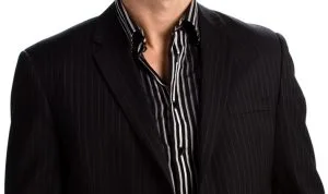 Close-up of a custom black pinstripe suit jacket layered over a black and white striped dress shirt, showcasing sleek contemporary tailoring and expert fabric pairing at From Collars to Cuffs in South Florida