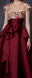 Model in a custom maroon ballgown featuring floral embroidery on the bodice and a dramatic ruffle bow detail, highlighting exquisite bespoke evening wear for galas at From Collars to Cuffs in South Florida