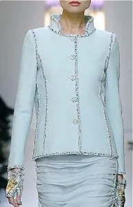 Model wearing a custom light blue tweed jacket with matching skirt featuring silver trim and buttons, highlighting elegant bespoke suit tailoring and premium textures at From Collars to Cuffs in Florida
