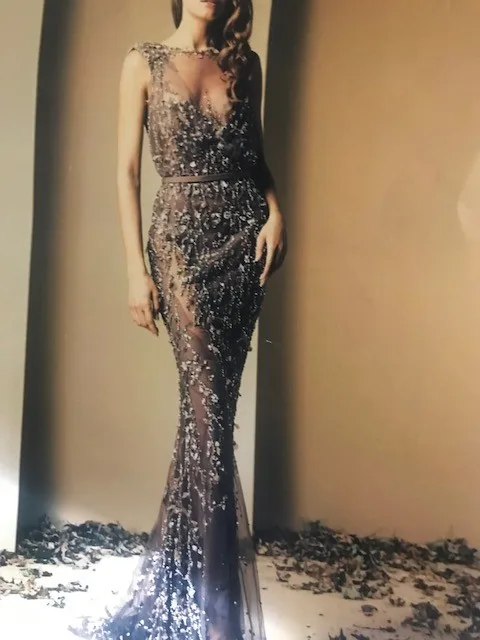 Model wearing a custom black beaded and sequined mermaid gown with a sheer train, showcasing luxury bespoke evening wear and expert embellishment craftsmanship at From Collars to Cuffs in South Florida.