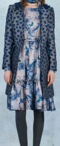 Woman wearing a custom blue floral print dress with a matching dotted coat overlay, showcasing sophisticated fabric coordination and bespoke layering techniques at From Collars to Cuffs in Weston, Florida