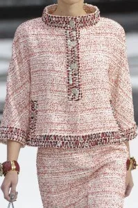 Woman wearing a custom pink bouclé tweed poncho top and matching skirt, showcasing elegant Chanel-inspired luxury fashion and bespoke tailoring at From Collars to Cuffs in South Florida