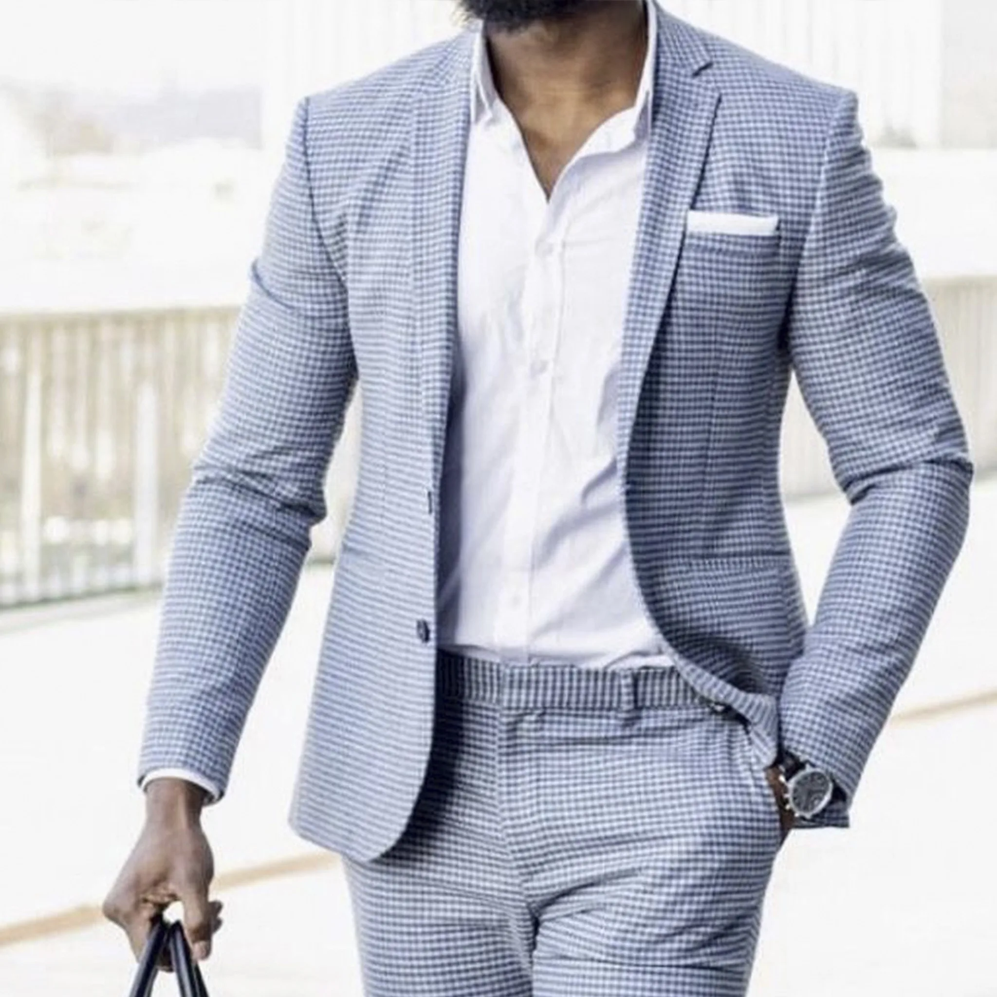 Man wearing a custom-fitted light blue checkered suit and white shirt, demonstrating the perfect fit guarantee of bespoke tailoring at From Collars to Cuffs in Weston, Florida