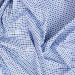Close-up of a premium blue and orange windowpane check fabric draped to show texture, representing high-quality bespoke fabric selection at From Collars to Cuffs in Weston, Florida.