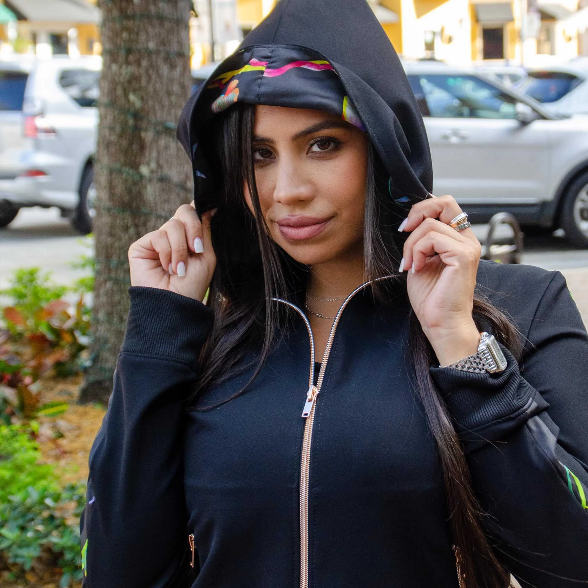 Model adjusting the hood of a custom-tailored black zip-up jacket with premium detailing, highlighting personalized casual outerwear craftsmanship at From Collars to Cuffs in Weston, Florida