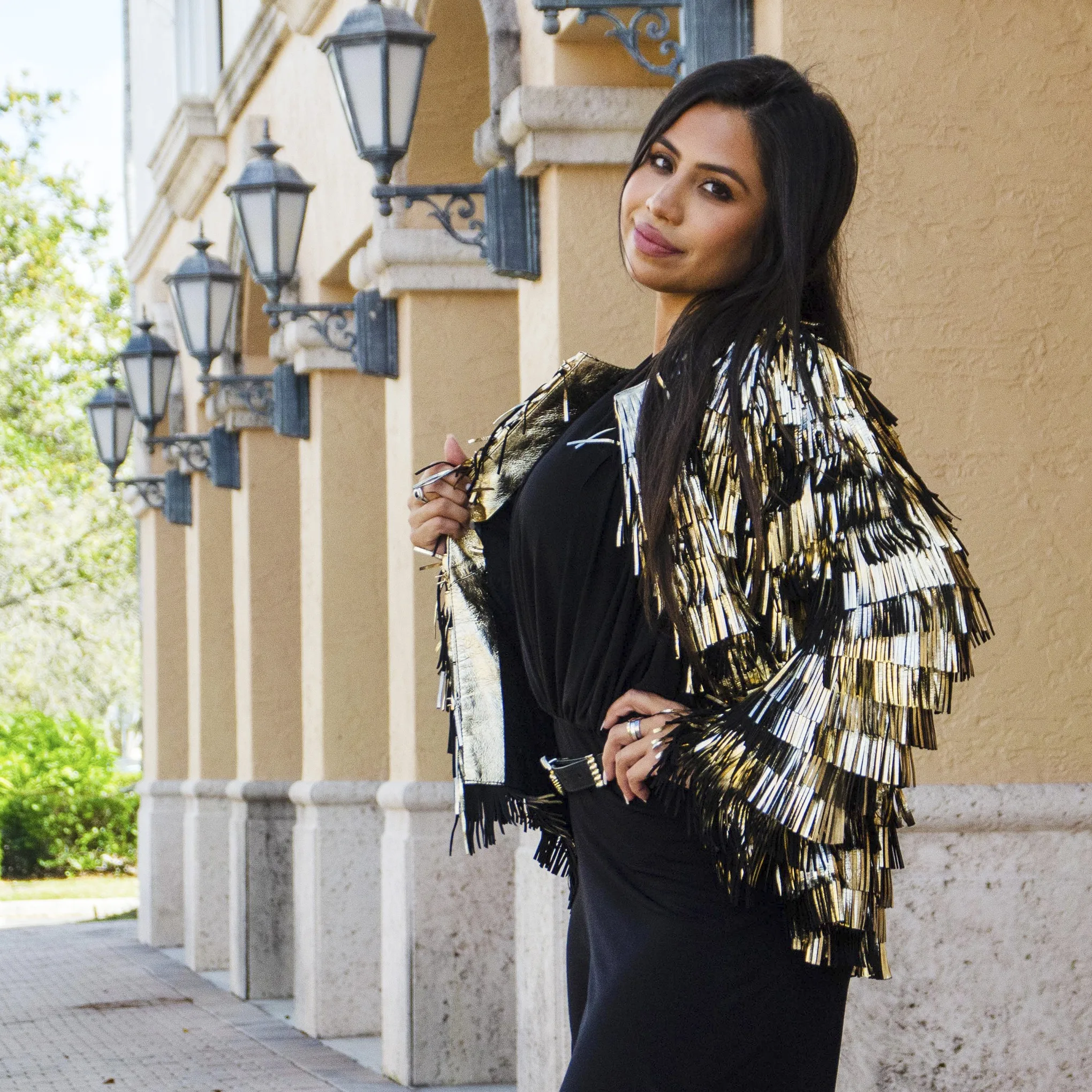 Model wearing a custom black jacket with gold fringe embellishments, showcasing statement bespoke outerwear for special occasions at From Collars to Cuffs in South Florida