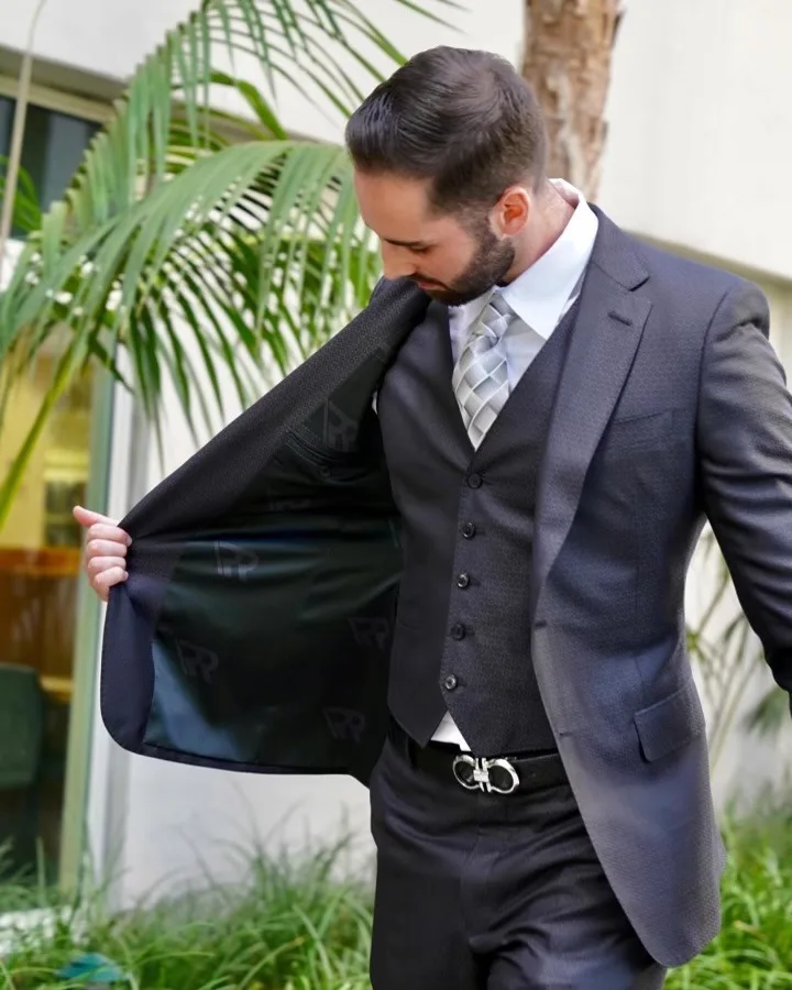 Bespoke suit jacket open to reveal custom monogrammed lining, showcasing personalized details and premium craftsmanship at From Collars to Cuffs in Weston, FL